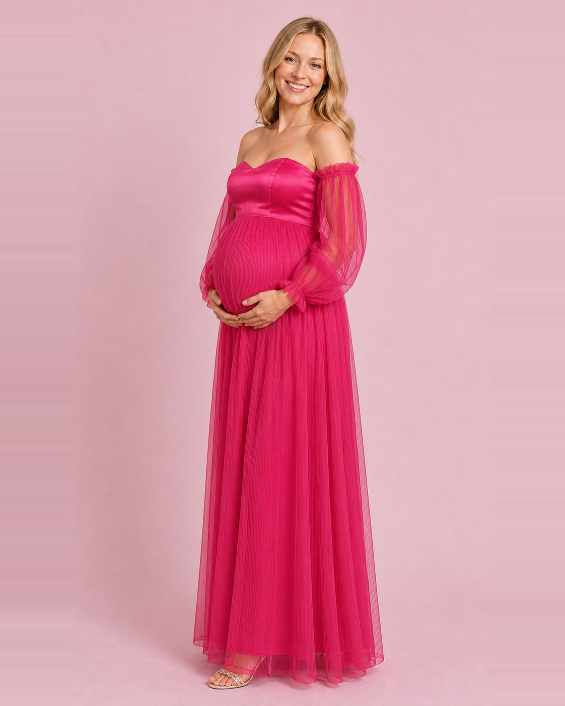 Three-quarter view of the fuchsia gown showing its raised waist, sheer sleeves and long pleated skirt.