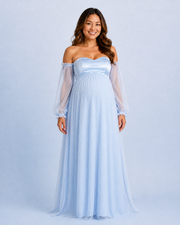 Front view of the sky blue maternity gown with a sweetheart neckline, sheer long sleeves and full-length pleated skirt.