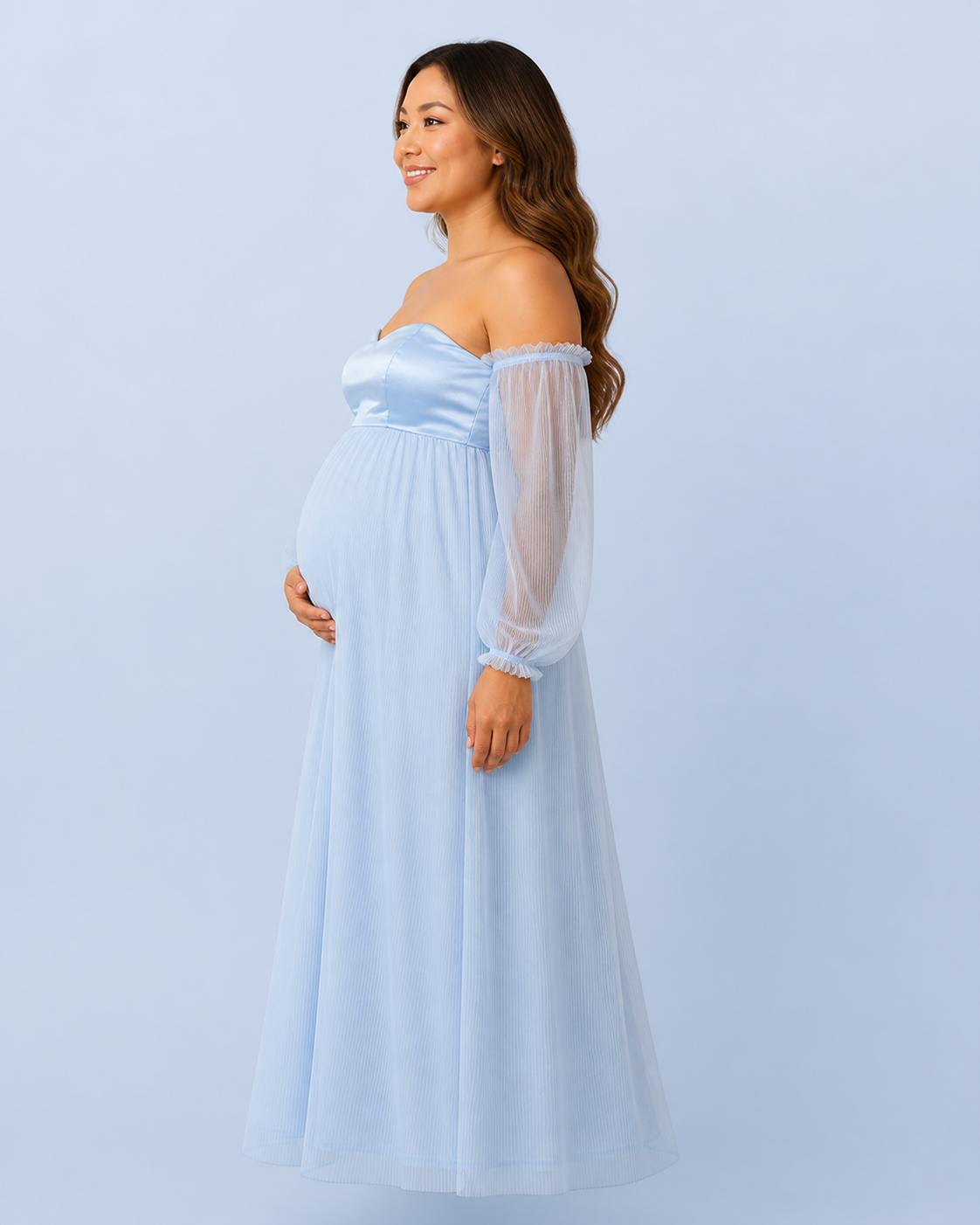 Side view of the sky blue gown showing the raised waist, sheer sleeve and long pleated silhouette.