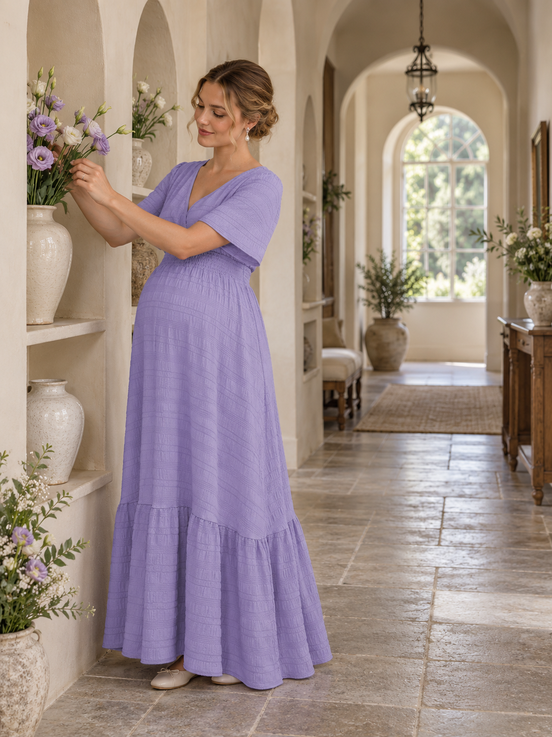 Eugenie Lavender maternity dress — arranging flowers in a sunlit hallway