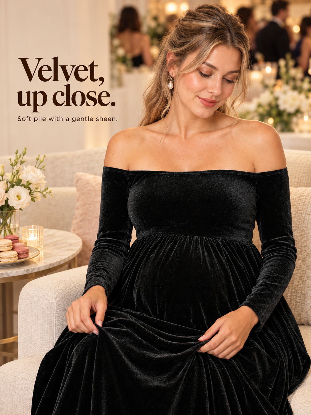 Colette Black maternity dress — sitting among candles in a cozy indoor lounge