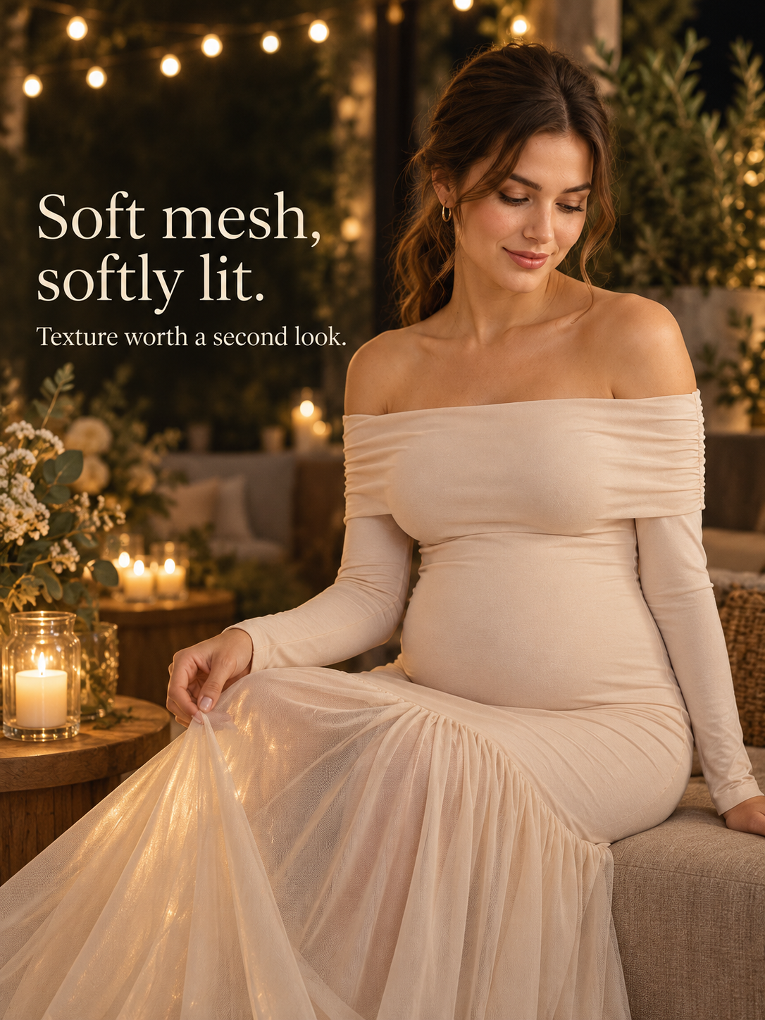 Gabrielle Champagne Beige maternity dress — seated by candlelight holding the mesh hem