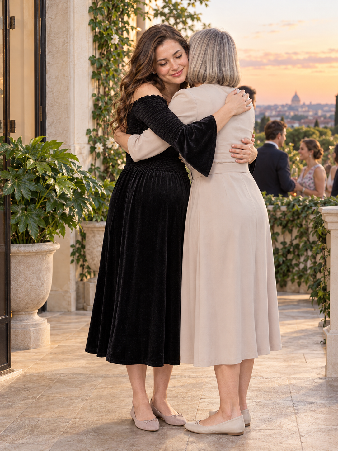 Talia Black maternity dress — embracing an older woman on a sunset rooftop terrace