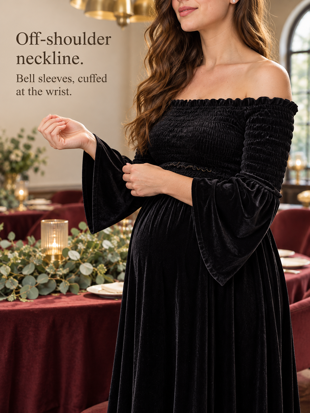 Talia Black maternity dress — touching the bell sleeve cuff at a string-lit dinner table