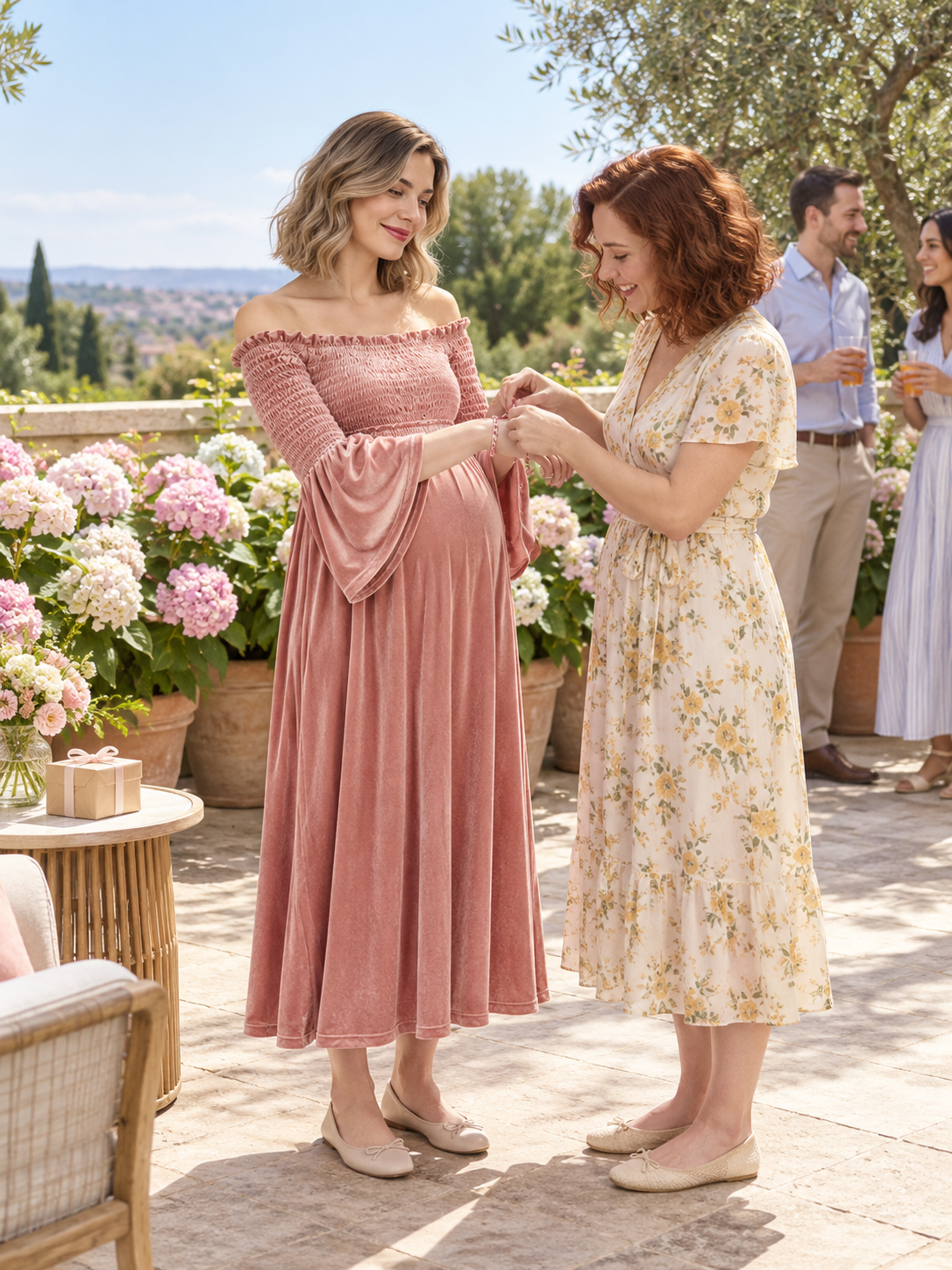 Talia Dusty Rose maternity dress — sharing a moment with a friend on a flower-filled terrace