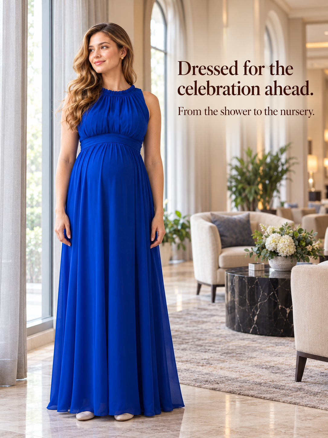 Annelise Royal Blue maternity dress — standing by a large window in a living room