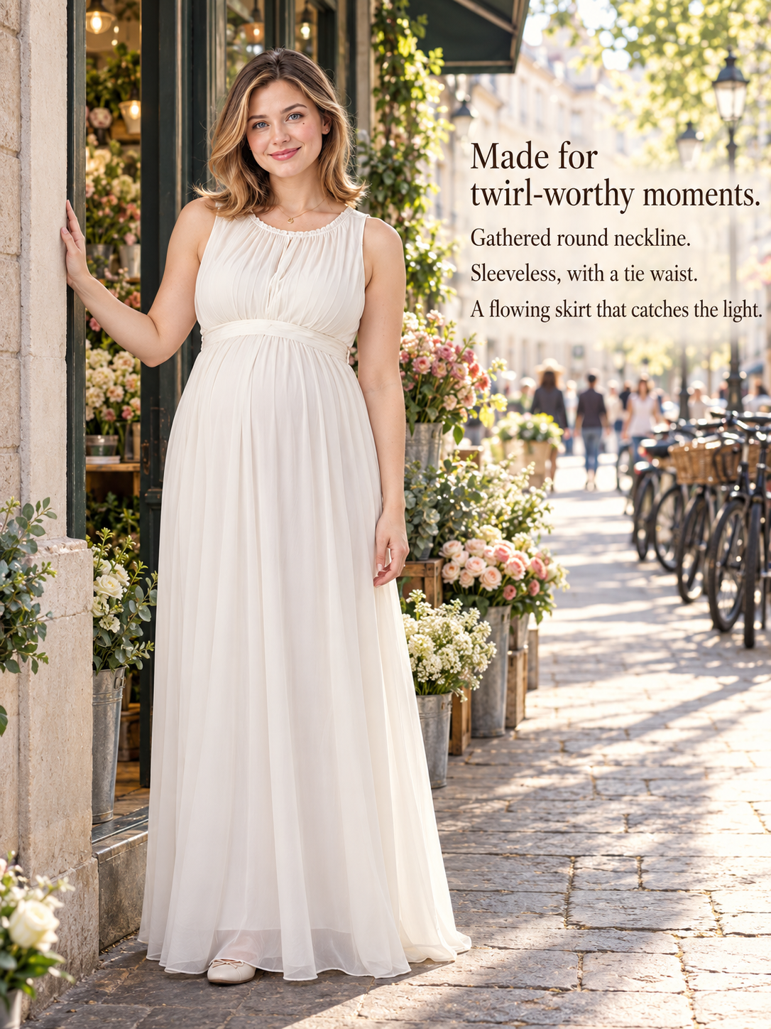 Annelise Ivory maternity dress — standing on a cobblestone street beside a bicycle