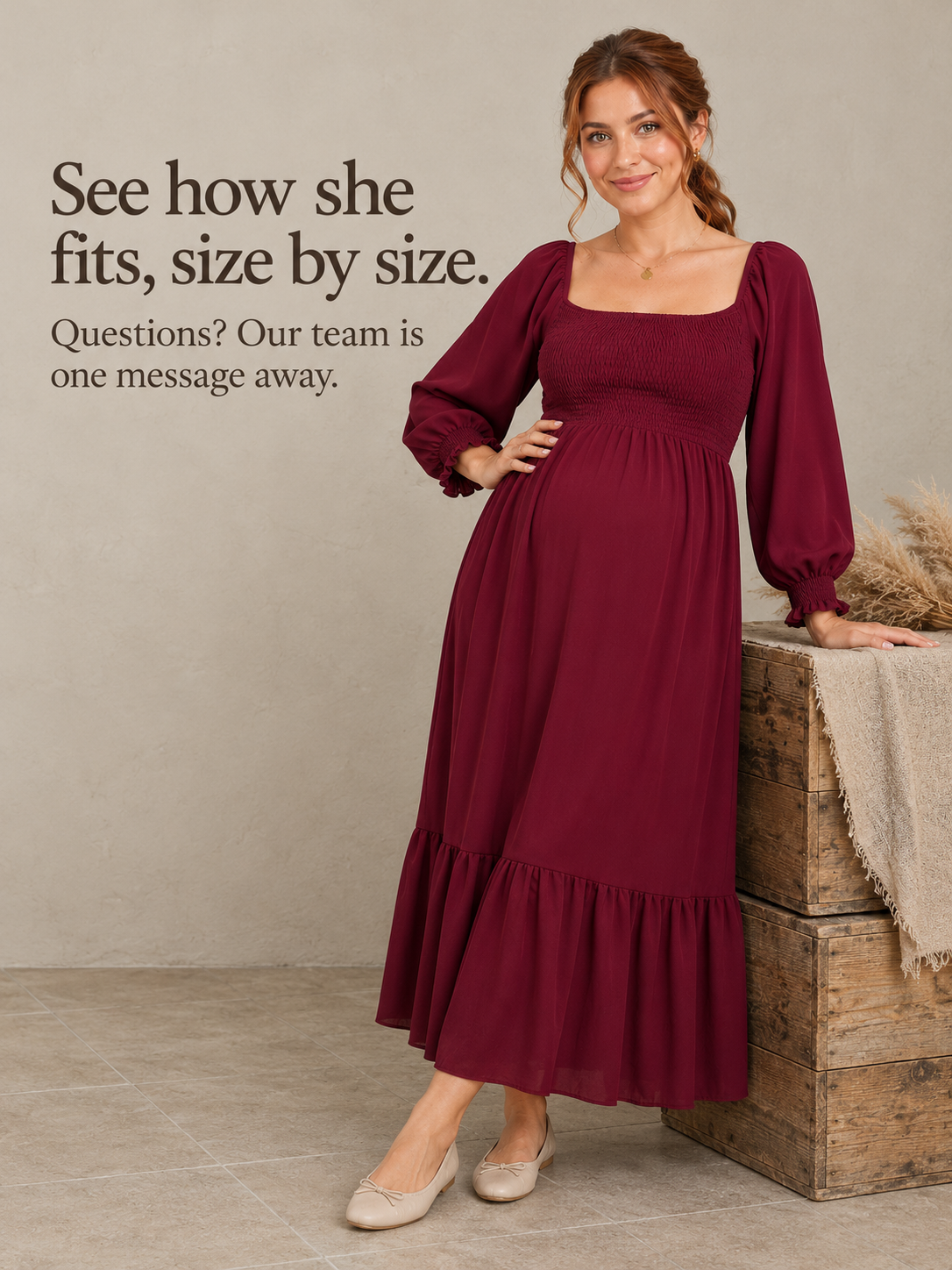 Cecily Wine Red maternity dress — standing beside a wooden crate
