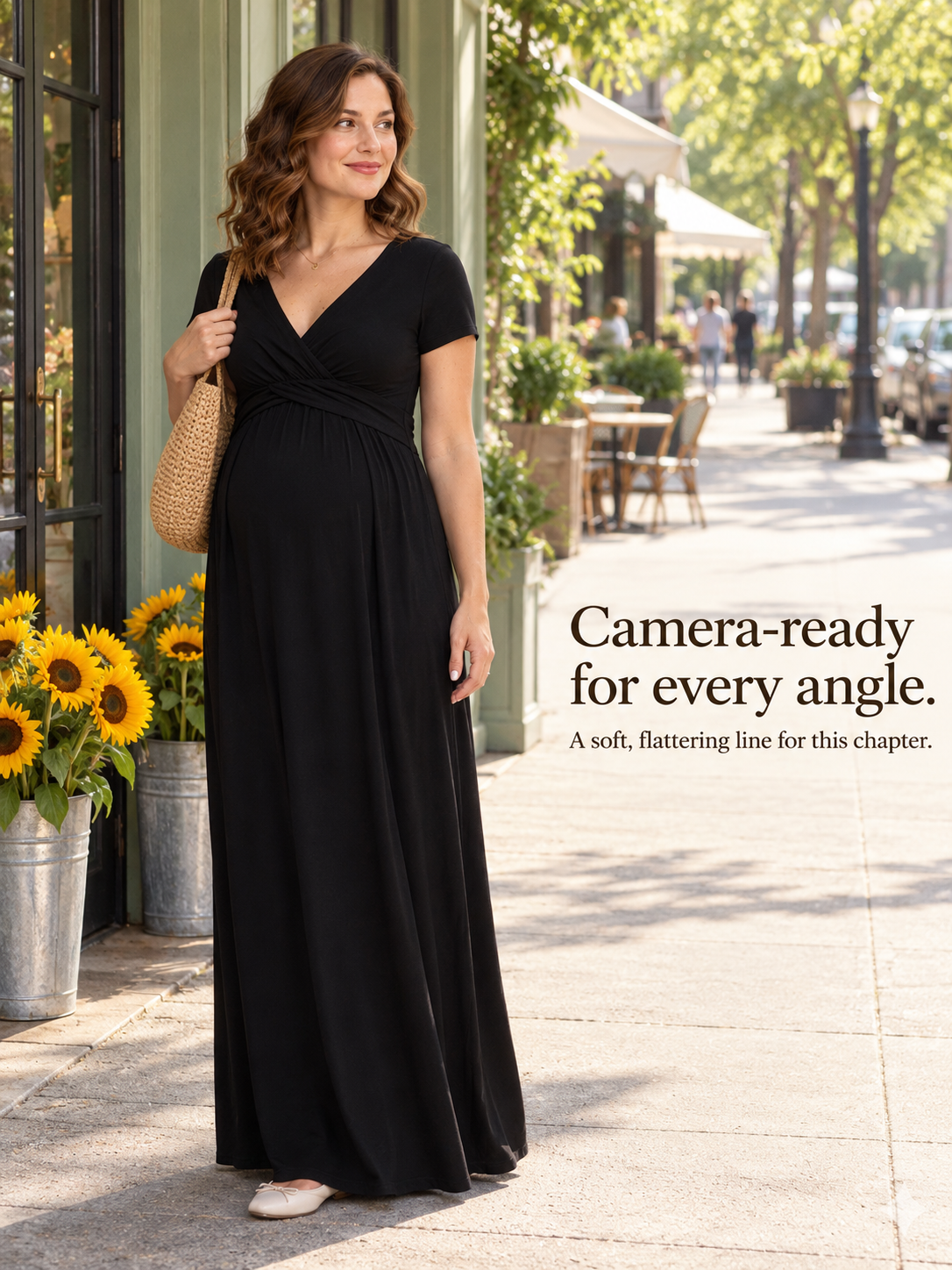 Lydia Black maternity dress — standing on a sidewalk beside buckets of sunflowers