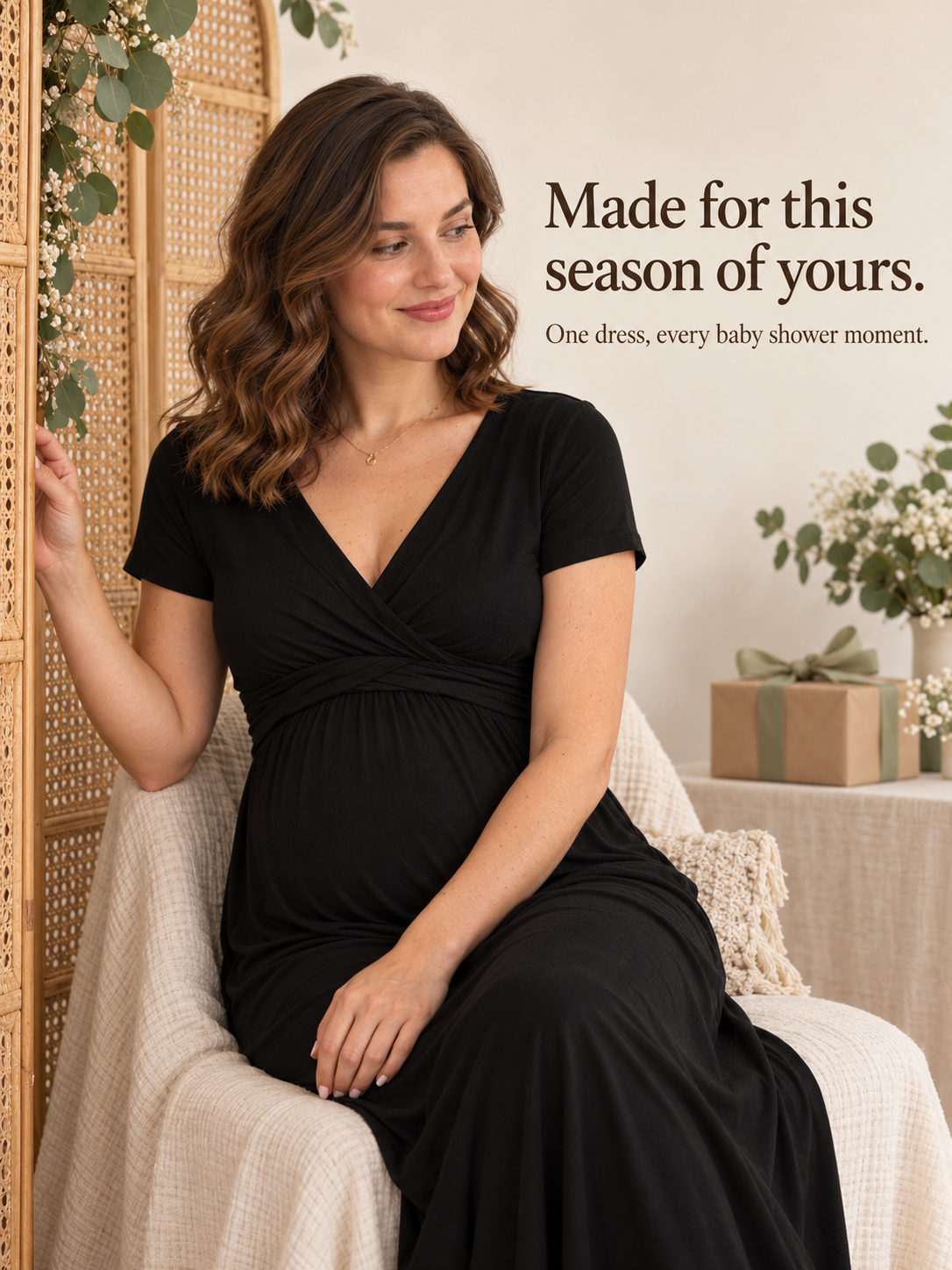 Lydia Black maternity dress — seated indoors on a woven chair near greenery