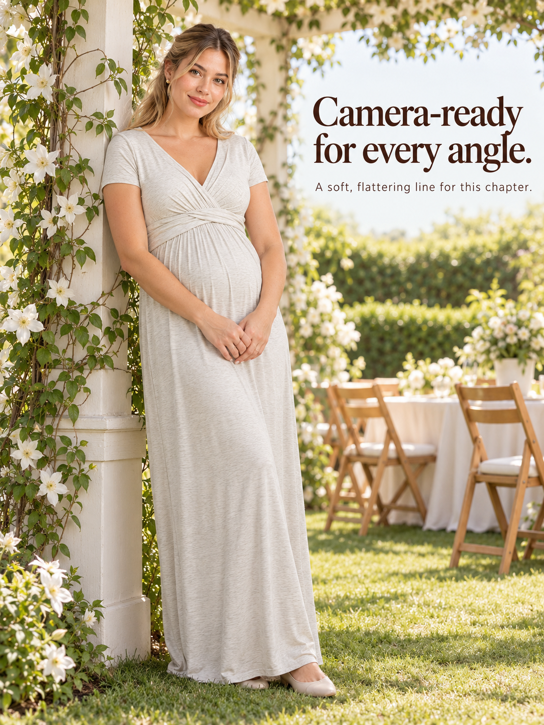Lydia Heather Gray maternity dress — standing in a garden near a flowering archway