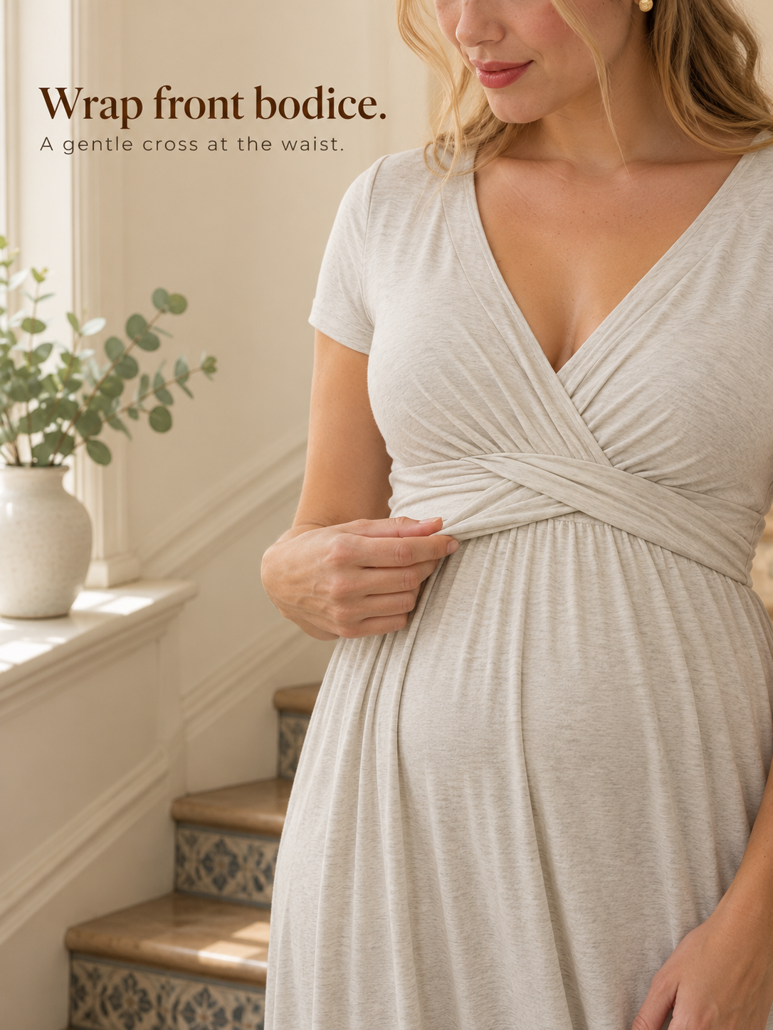 Lydia Heather Gray maternity dress — standing indoors near a staircase, hand at the wrap bodice