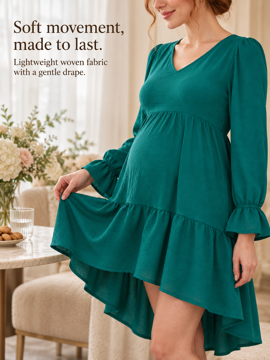 Mila Emerald maternity dress — standing, holding out the tiered skirt hem