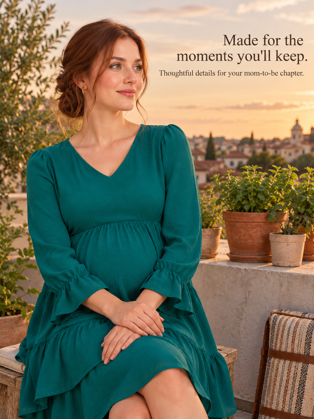 Mila Emerald maternity dress — seated outdoors at sunset with a city view
