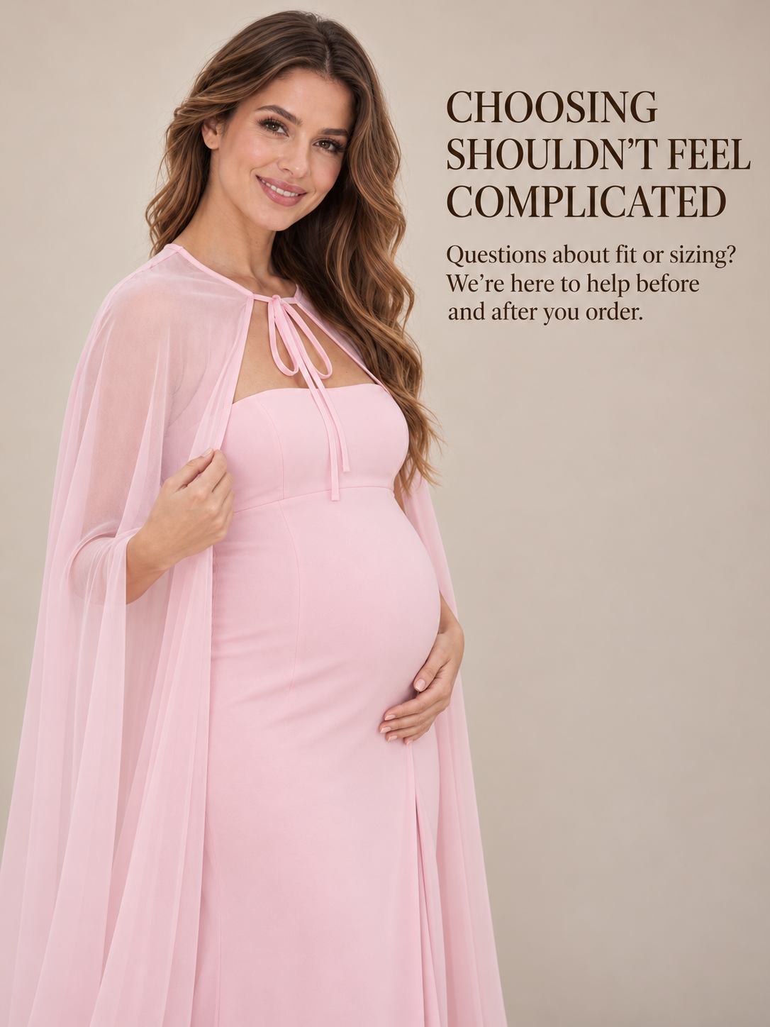 Rosamund Light Pink maternity dress — holding the cape edge in a warm studio portrait