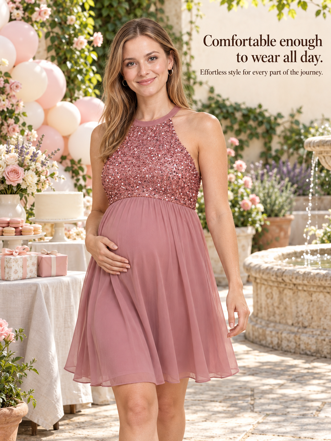 Evelina Dusty Pink maternity dress — standing in a garden courtyard beside a stone fountain