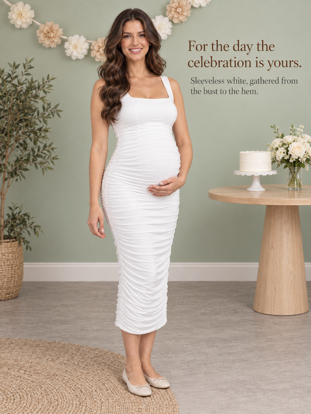 Leonie White maternity dress — celebration corner with a paper flower garland and cake