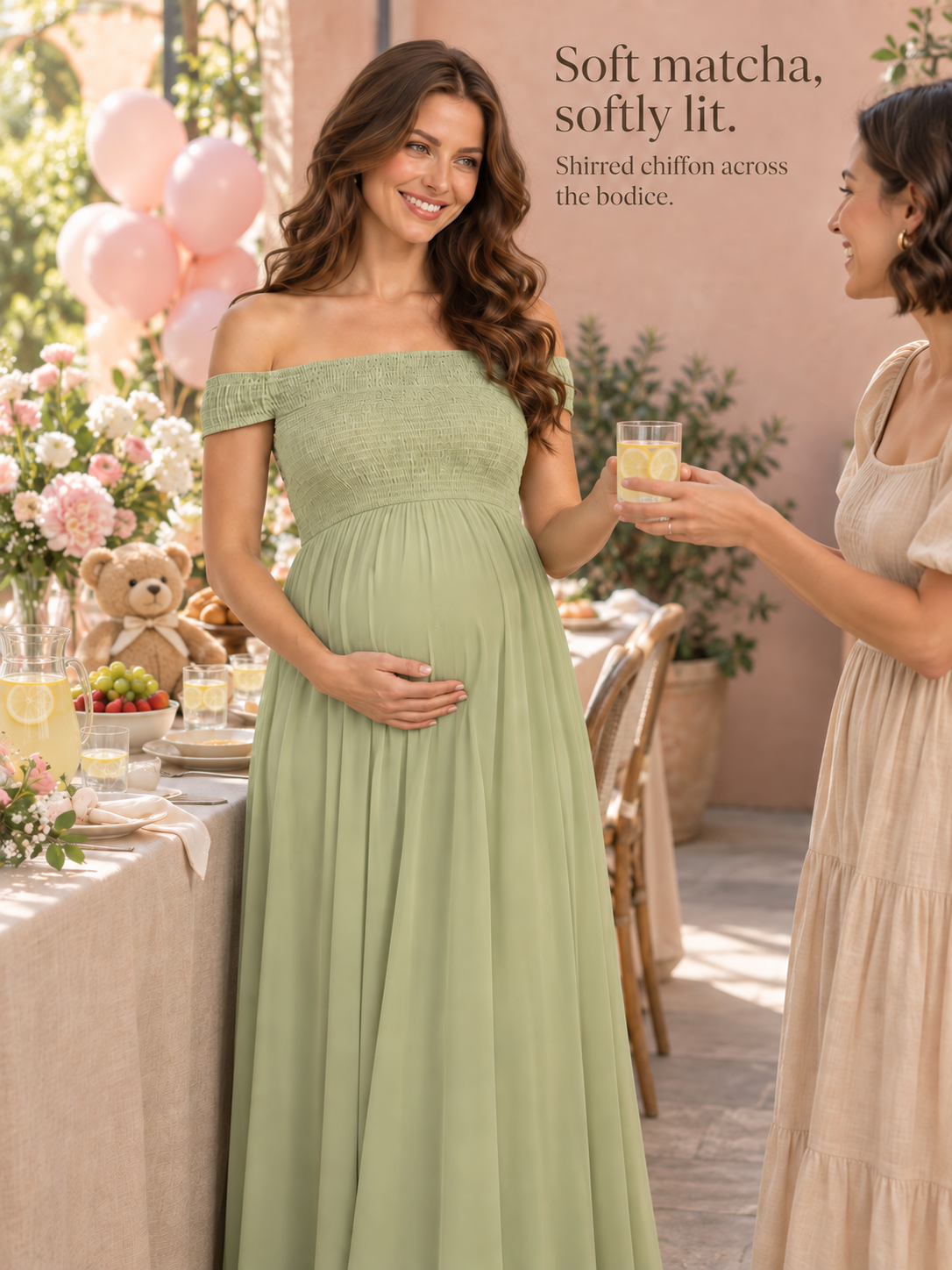 Iris Sage Green maternity dress — shirred bodice and chiffon in soft light with a friend