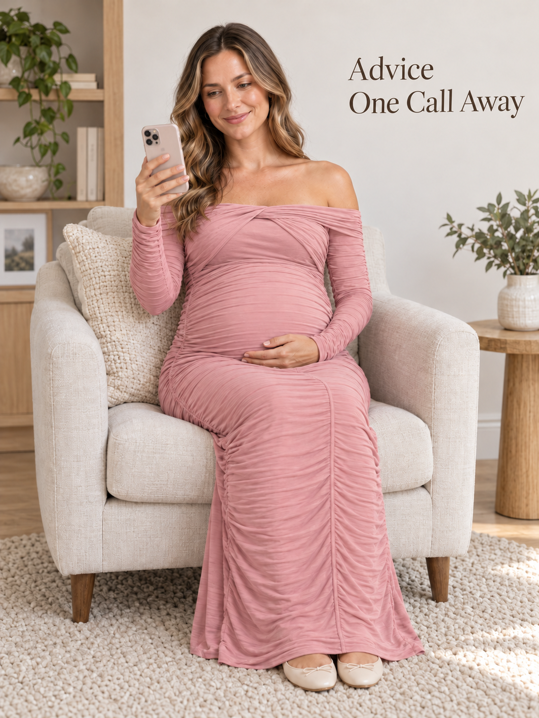Imogen Mauve maternity dress — seated in an armchair holding her phone