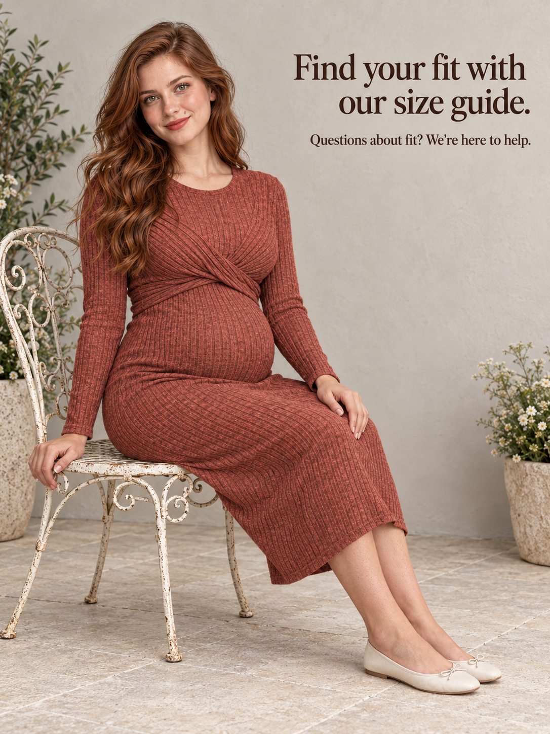 Maeve Rust Red maternity dress — seated in a wrought iron chair on a patio