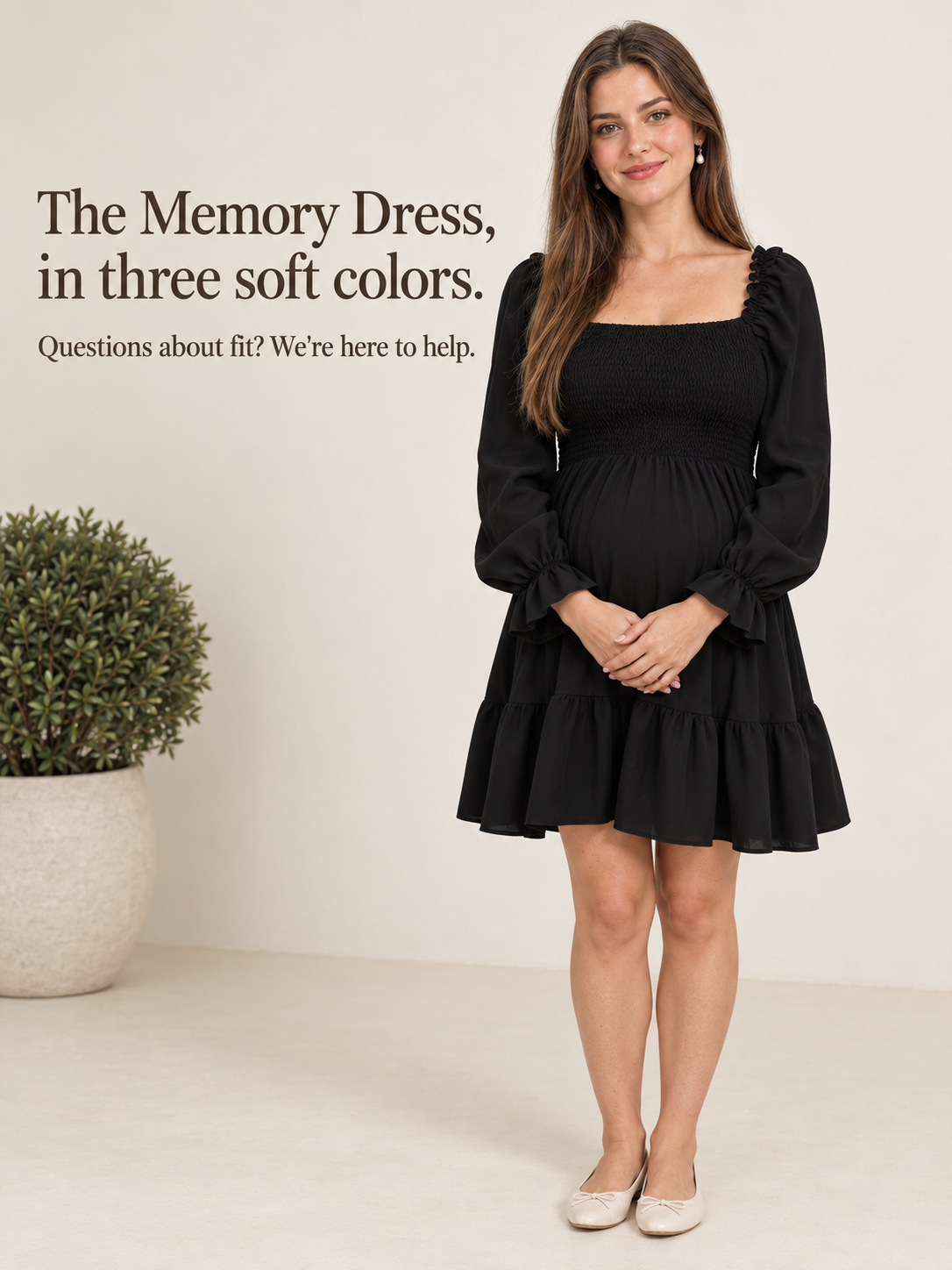 Penelope Black maternity dress — standing against a plain wall with hands near the belly