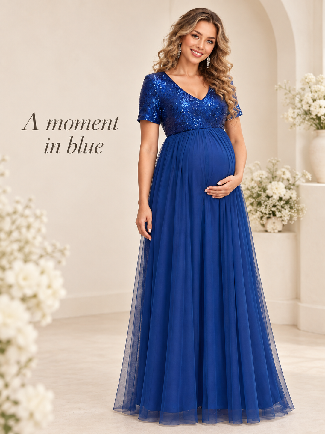 Celestine Royal Blue maternity dress — full-length view in a softly lit room with flowers