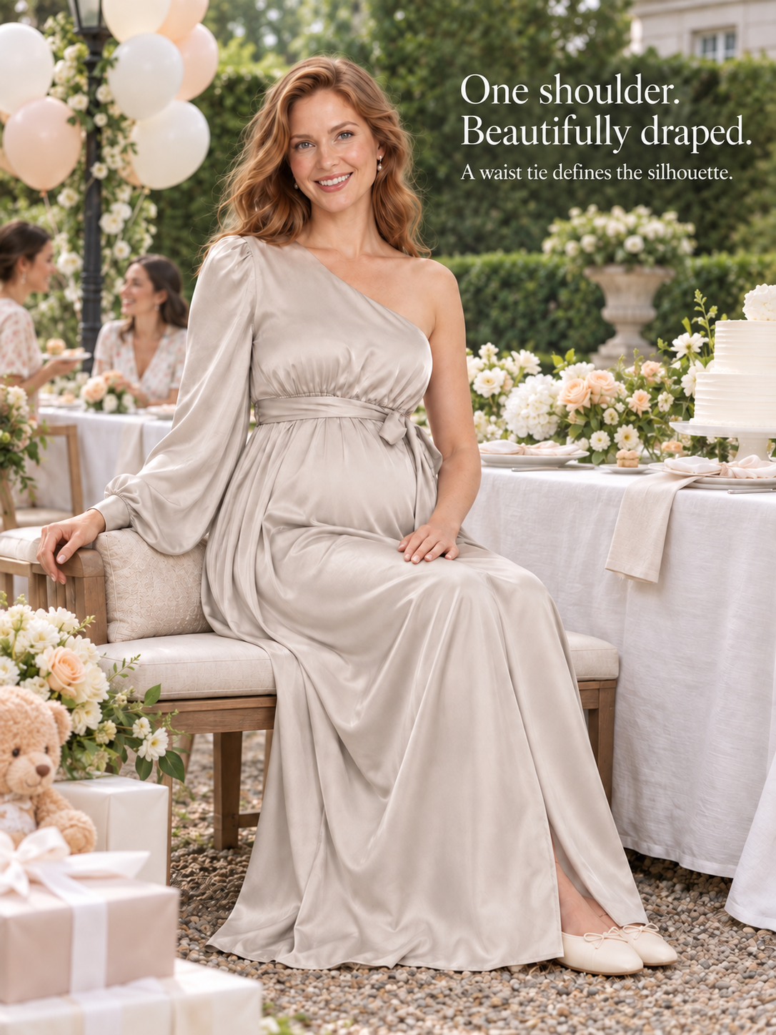 Sylvie Dove Gray maternity dress — seated on a garden bench, the skirt draped softly to the ground