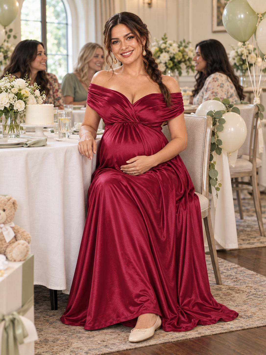 Cressida Wine Red maternity dress — seated at a baby shower table with friends behind her
