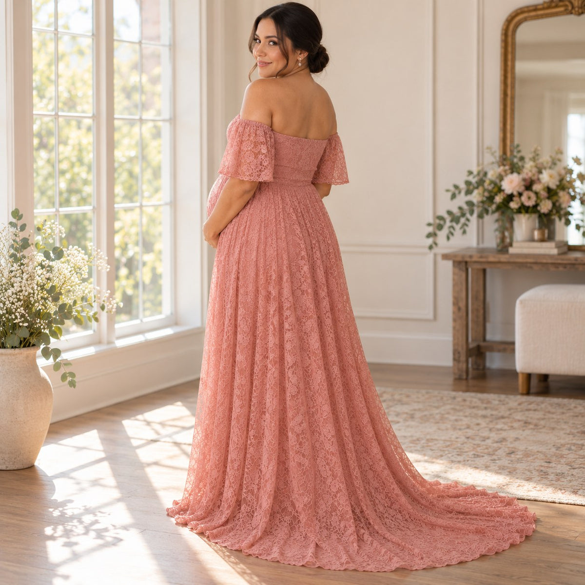 Back view of the blush pink lace maternity dress with flutter sleeves and a trailing hem