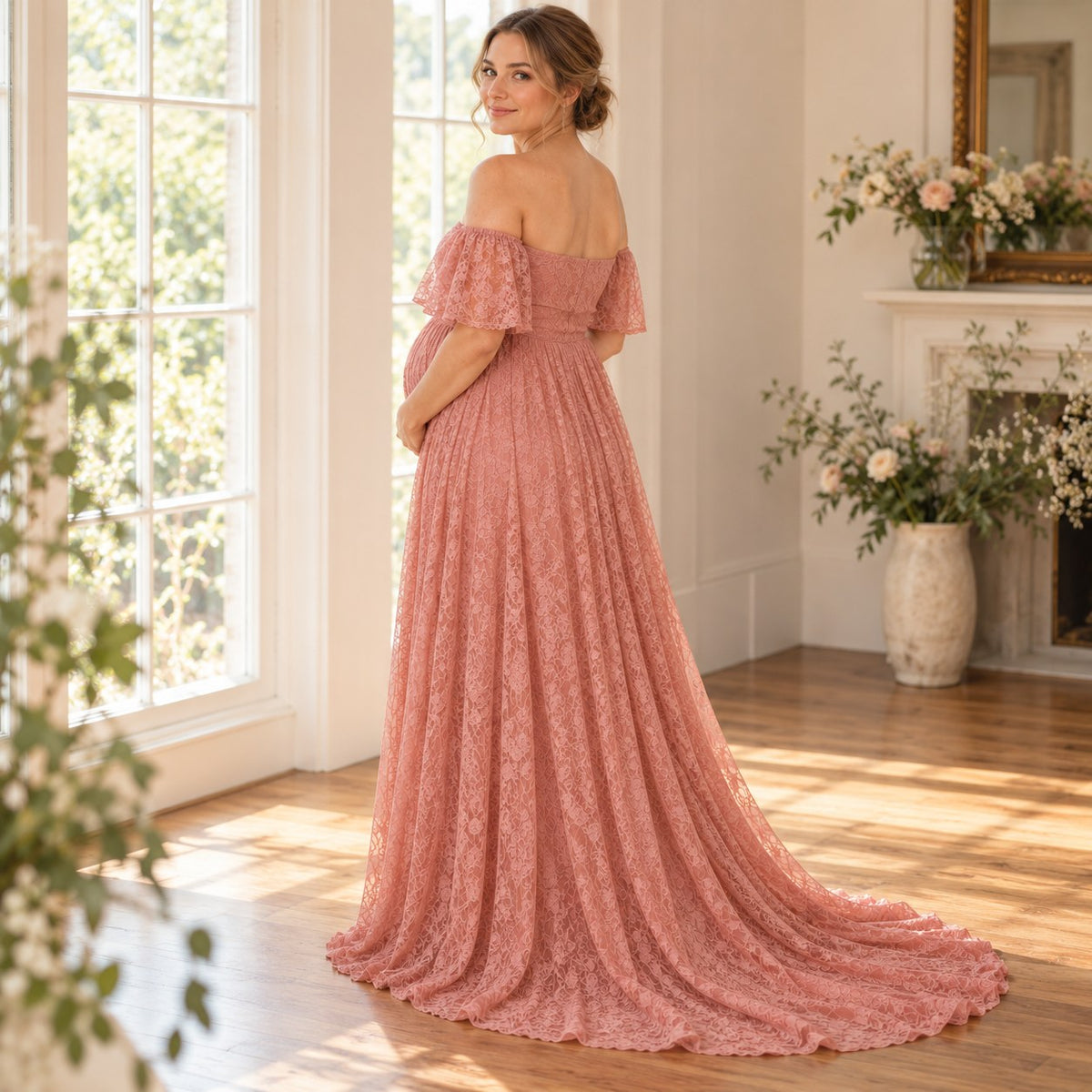 Back view of the blush pink lace maternity dress with flutter sleeves and a trailing hem