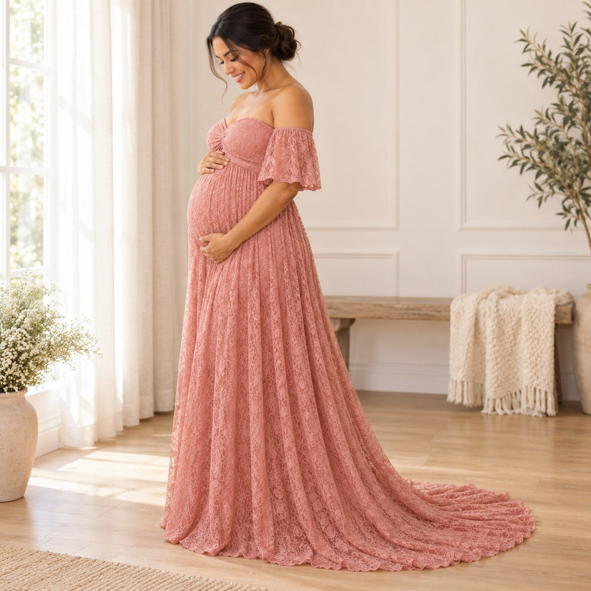 Side view of the blush pink lace maternity dress with an empire seam and a long trailing hem