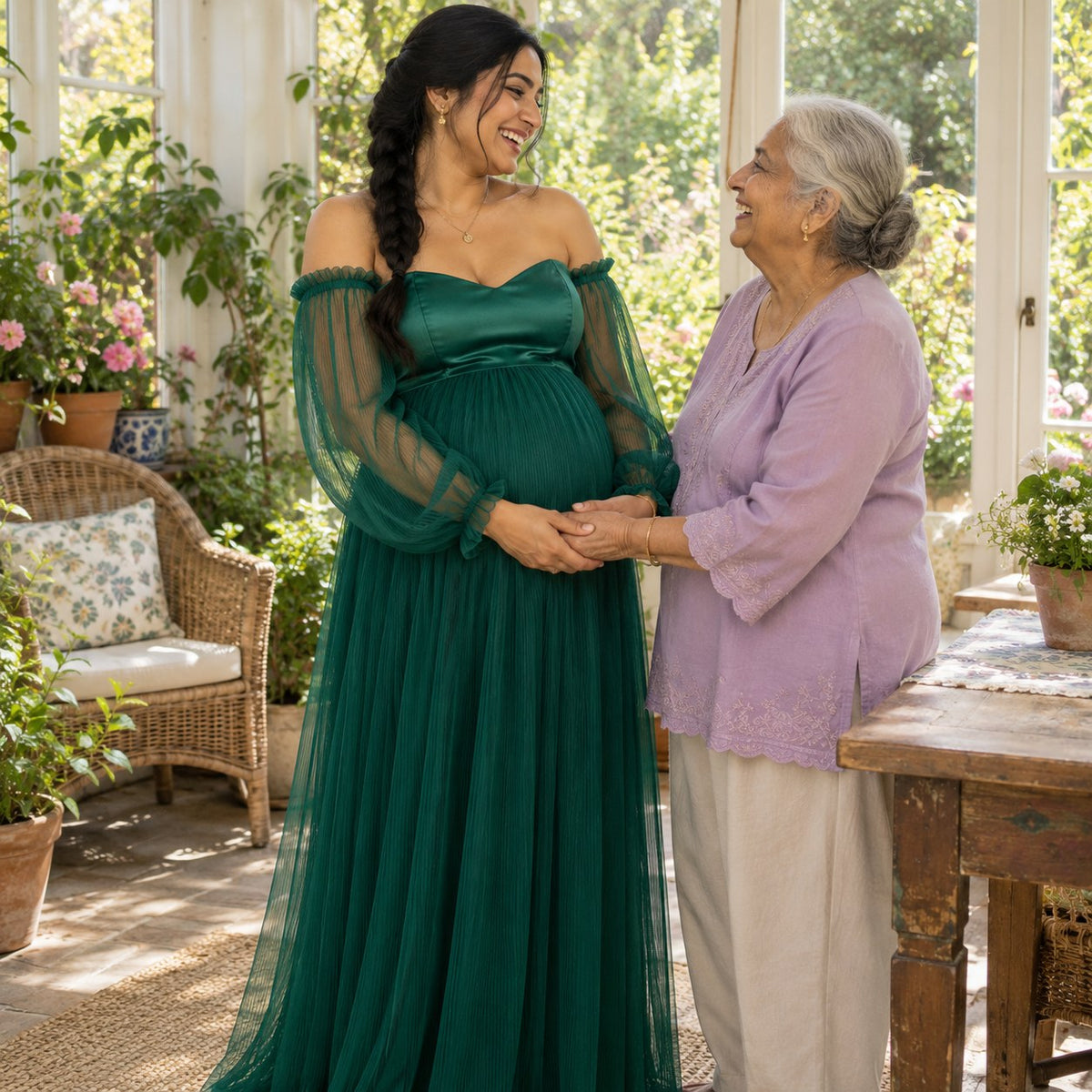 Mom-to-be in a deep emerald gown holding hands with her grandmother in a garden room