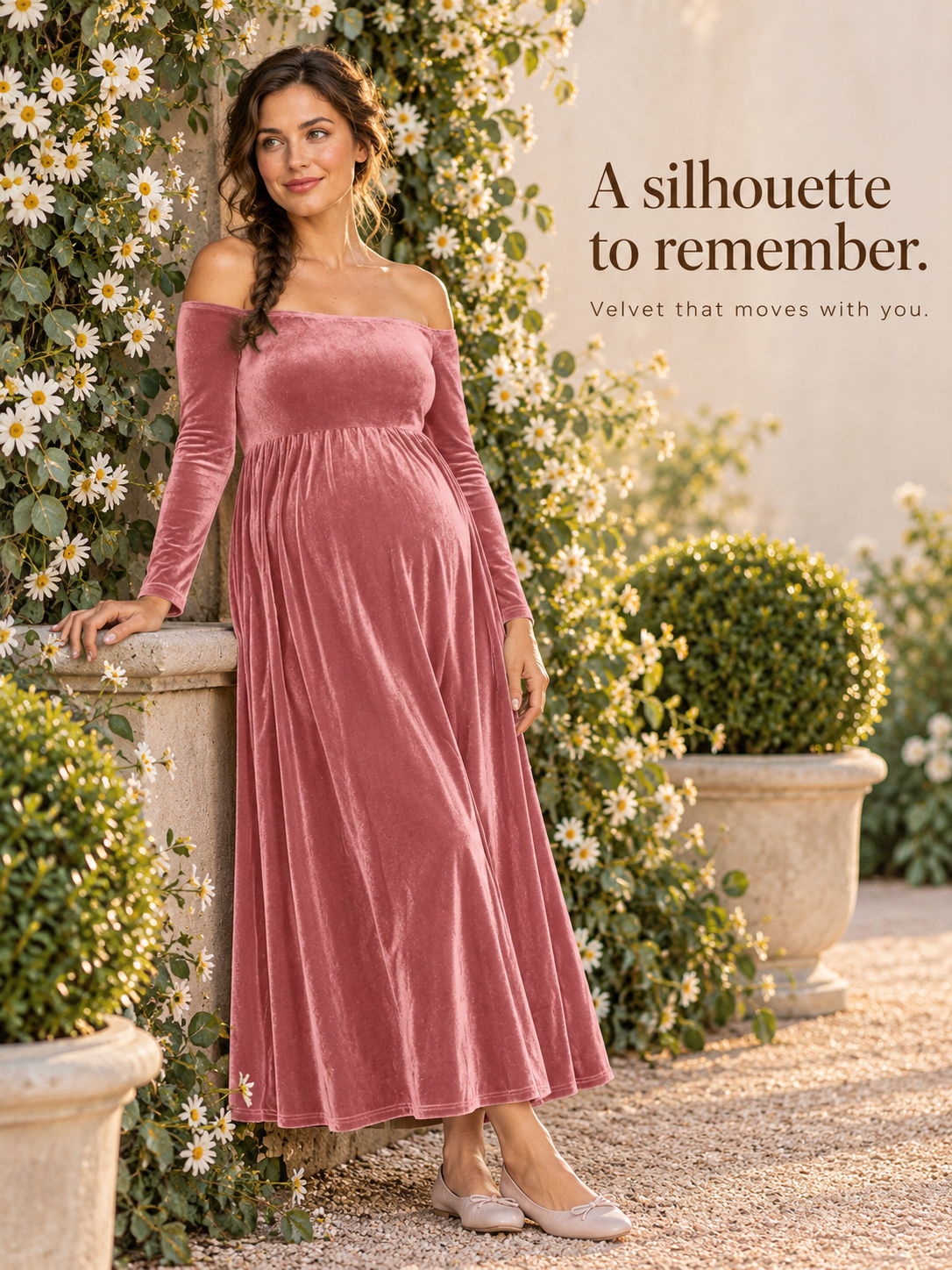 Colette Dusty Rose maternity dress — standing by a vine-covered stone wall in a garden