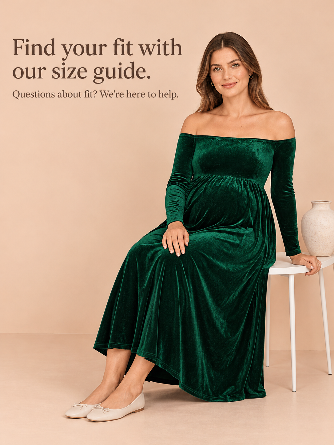 Colette Forest Green maternity dress — seated on a stool against a plain studio background